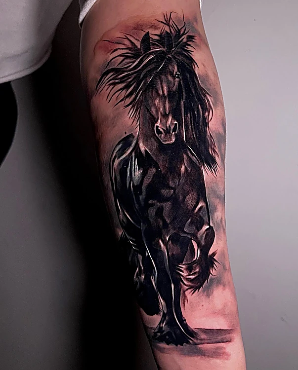 Caballo negro galopando con la crin al viento, realismo oscuro en el antebrazo