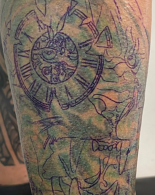 Antes del cover-up: la calca morada de un reloj y un león dibujada sobre un tatuaje viejo de tinta verde
